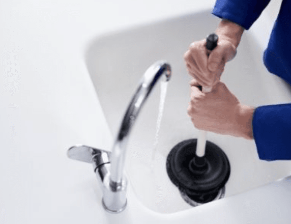 Plunger being worked on sink drain