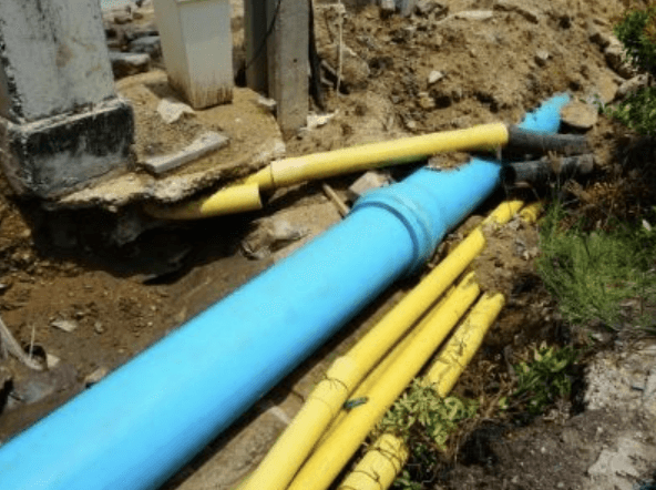 Turqouise and yellow sewage pipes in the dirt